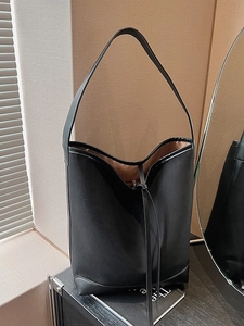 Minimalist black leather bucket tote bag with contrast panels and spacious interior