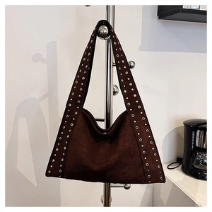 Detail of coffee brown suede tote bag featuring vintage metal rivets and eyelets