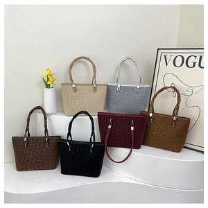 Dettaglio di borse tote leopardate con manici a corda intrecciata su supporti espositivi