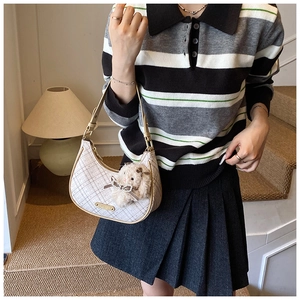 Detail of crescent shoulder bag with plaid pattern, plush bunny charm and bow detail