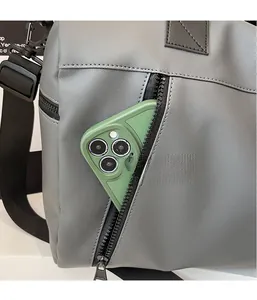 Close-up of grey nylon travel bag showing side zipper pocket and storage for accessories