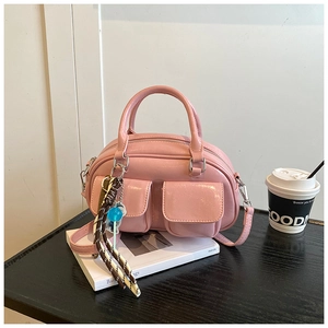 Borsa a bauletto rosa in ecopelle con doppie tasche anteriori e ciondolo intrecciato