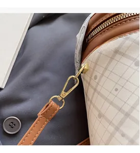 Close-up of golden metal buckle and diamond lattice fabric on the shoulder bag
