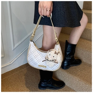 Close-up of light plaid hobo bag with leather handle and a cute plush sheep pendant