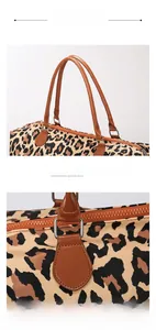 Detail of leopard print travel bag featuring brown leather handles and reinforced stitching