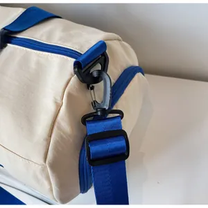 Detail of the durable black hook and blue nylon shoulder strap on the travel bag