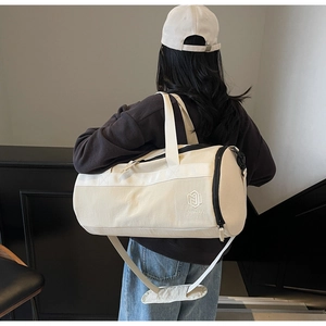 Détail du sac de sport en toile beige avec broderie NINGJIA et poche filet latérale