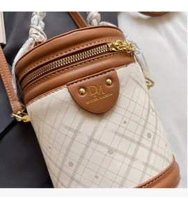 Detail of checkered bucket bag with silk scarf handle and golden brand hardware