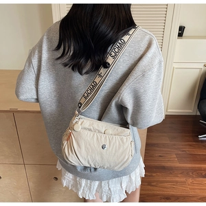 Detail of beige nylon crossbody bag with multi-pocket design and wide jacquard logo strap