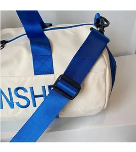 Detail of adjustable blue shoulder strap and NSH embroidery on white gym bag