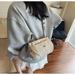 Detail of beige wrinkled nylon crossbody bag with stylish jacquard letter strap
