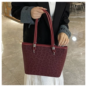Dettaglio della borsa tote scamosciata bordeaux con stampa leopardata e finiture
