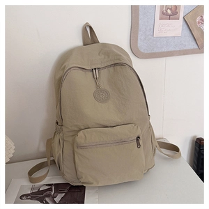 Vue détaillée du sac à dos en nylon kaki avec poche zippée et logo SPORT en relief