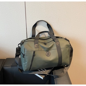 Detailed close-up of water-resistant matte green travel bag with sturdy handles and shoulder strap
