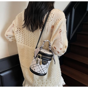 Close-up of quilted bucket bag with polka dot scarf detail and gold hardware