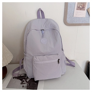 Vue détaillée d'un sac à dos en nylon violet clair avec logo SPORTS circulaire sur bureau