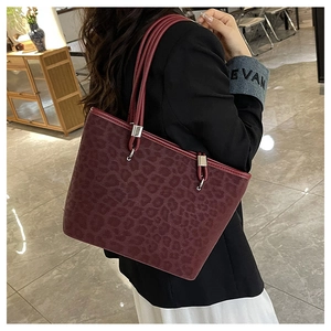 Dettaglio della borsa tote bordeaux con stampa leopardata e finiture argentate