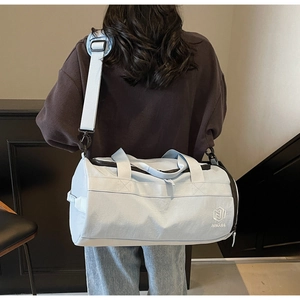 Détail du sac de sport cylindrique bleu clair avec logo NINGJIA et sangle réglable