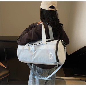 Détail du sac de sport bleu clair avec poche latérale en filet et logo brodé de qualité