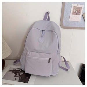 Vue détaillée de dessus d'un sac à dos décontracté lilas sur un bureau blanc épuré