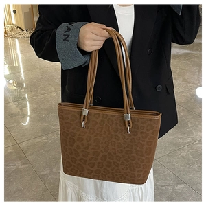 Dettaglio della borsa leopardata marrone con manici in similpelle e anelli d'argento