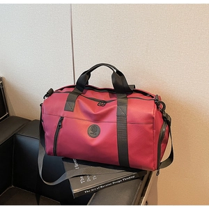 Detailed view of dark red travel bag with durable straps and front zip pocket