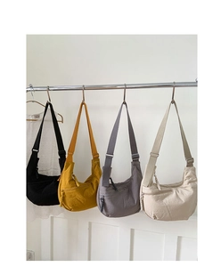 Detail of four colorful nylon hobo bags with adjustable straps and woven zip pulls