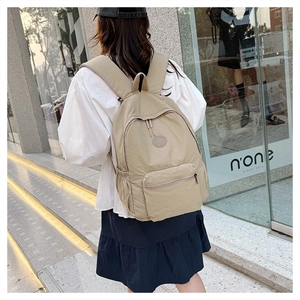 Détail de la poche latérale et texture en nylon kaki du sac à dos de voyage décontracté