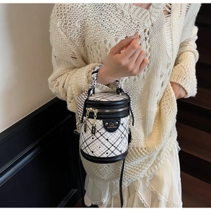 Close-up of quilted bucket bag with silk scarf handle and golden metal accents