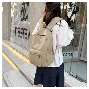 Vue détaillée d'un sac à dos en nylon kaki porté par un modèle dans un cadre urbain