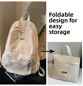 Foldable beige nylon backpack showing compact storage detail and brand label