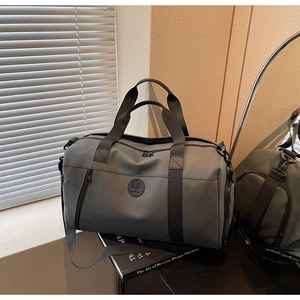Detail view of grey travel bag with textured fabric and adjustable strap in lifestyle setting
