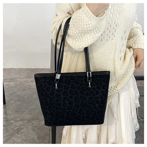 Dettaglio della borsa tote leopardata con anelli in metallo e sottili manici neri
