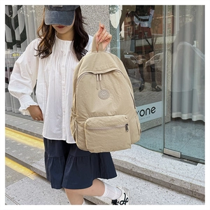 Vue détaillée du sac à dos en nylon kaki avec poche avant zippée et porte-bouteille latéral