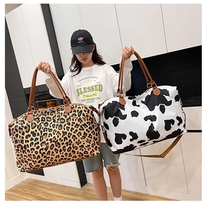 Fashionable leopard and cow print travel bags with brown leather handles in a macro view