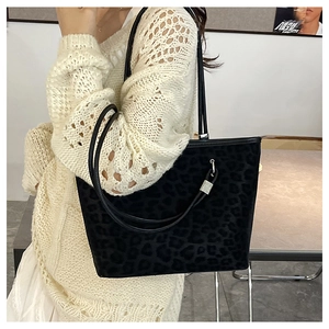 Dettaglio della texture leopardata della borsa tote e del raffinato manico in pelle