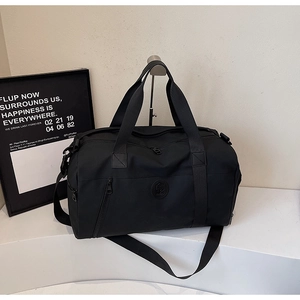 Close-up of black travel bag showing durable fabric texture and side zipper pocket