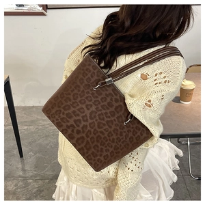 Dettaglio della borsa tote leopardata con spalline marroni e accenti in metallo argento