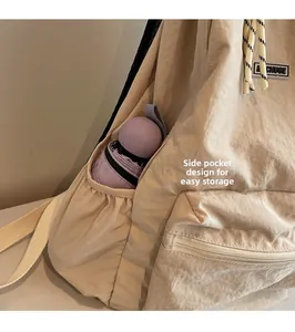 Detail of beige backpack side pocket with elasticated opening holding a purple umbrella