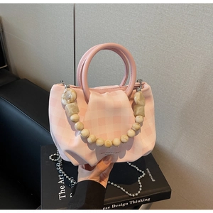 Dettaglio della borsa a quadri rosa con catena di marmo e tracolla in metallo