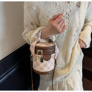 Detail of checkered bucket bag with silk scarf handle and gold hardware locks