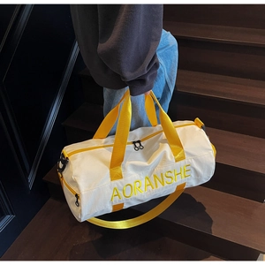 Detailed view of a yellow and white gym bag being carried on stairs by a model