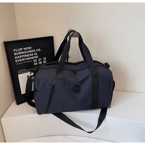 Detail of navy nylon travel bag with logo and adjustable padded shoulder strap