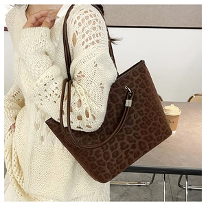 Dettaglio della borsa tote leopardata con texture scamosciata e manici sottili in pelle