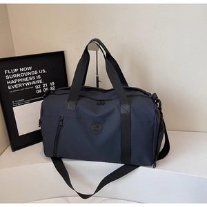 Detail of navy blue travel bag with adjustable strap and multiple storage pockets