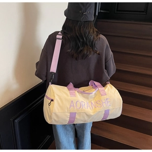 Rear view of a model wearing the beige and purple travel bag on indoor stairs
