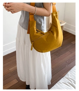 Ginger yellow crescent crossbody bag with thick woven zipper detail and wide strap