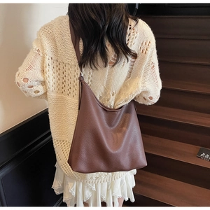 Model showing dark brown leather hobo bag with pebble texture and large capacity