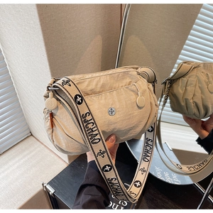 Close-up of beige nylon crossbody bag featuring jacquard patterned strap and drawstring