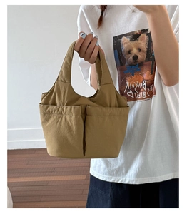 Detail of khaki canvas bucket bag with functional double front pockets and sturdy handles